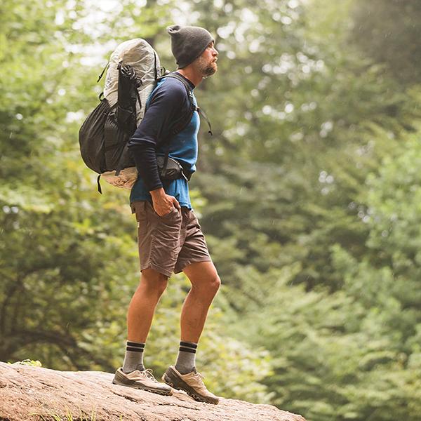 Man hiking in the woods. Shop men's hiking and outdoor socks